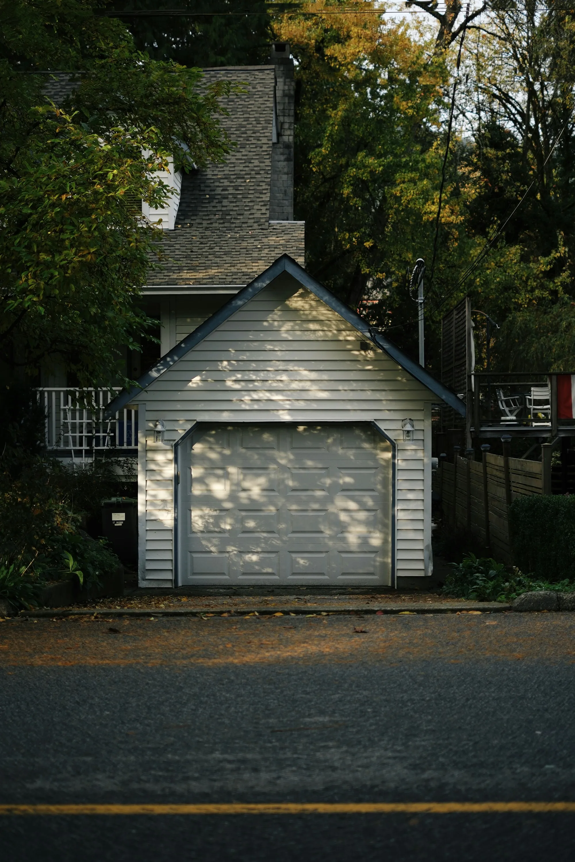 Detached garage with a white door and a short driveway